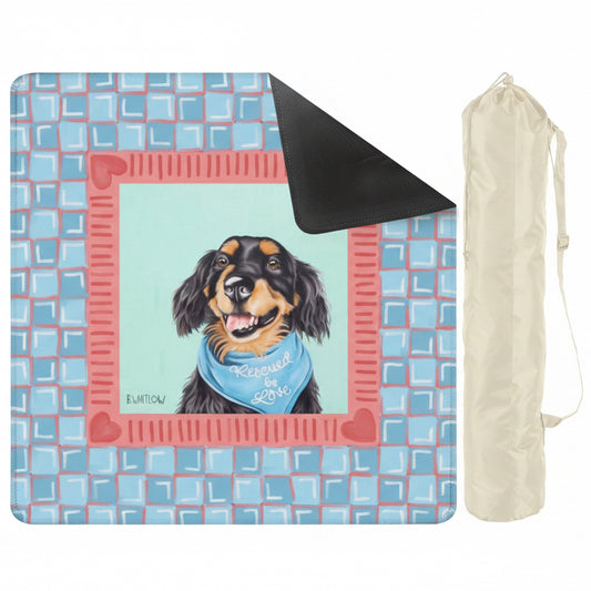 Outdoor mat with dog illustration and text, accompanied by a black carrying bag on a white background