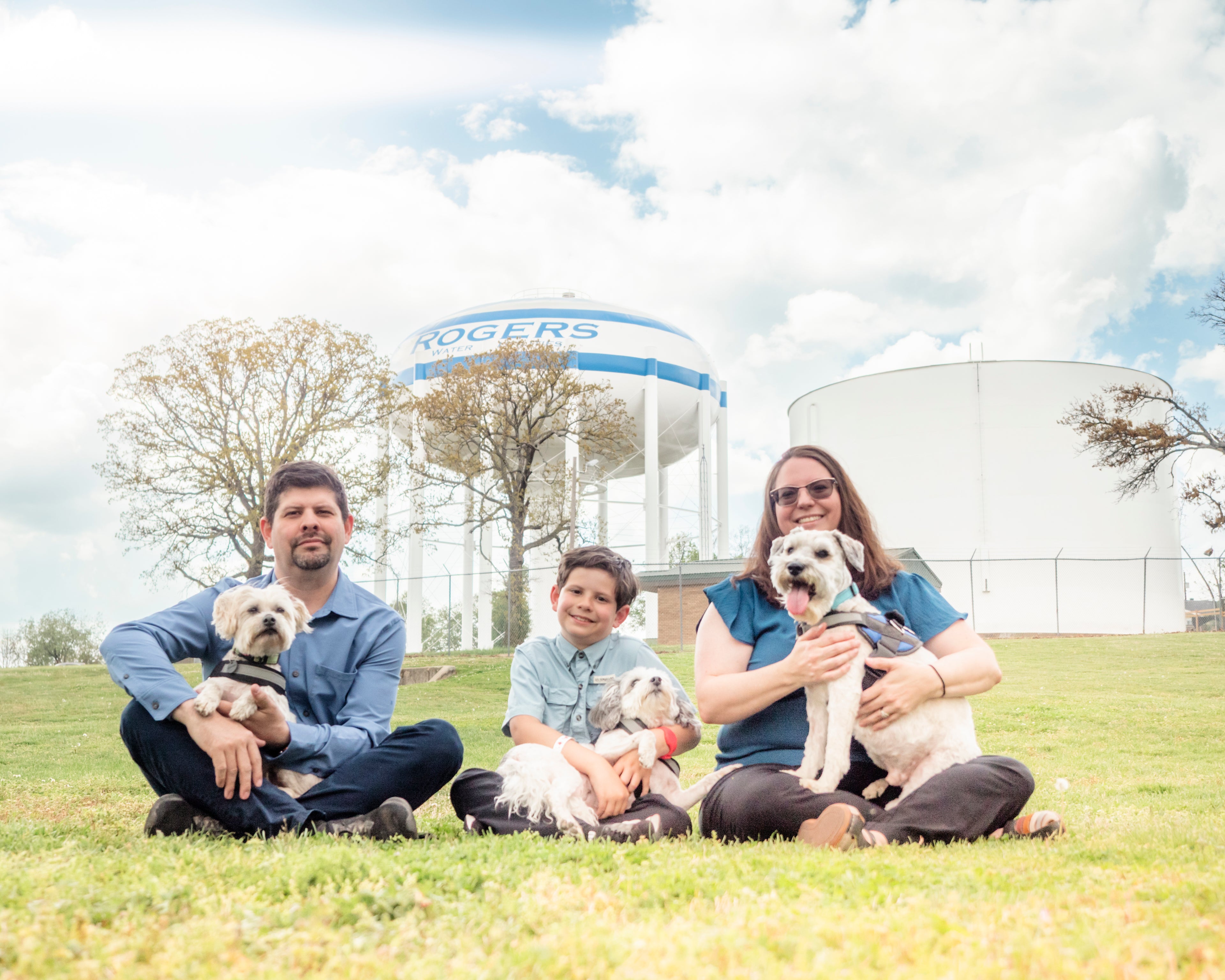 Family with dogs in a park with a water tower in the background
