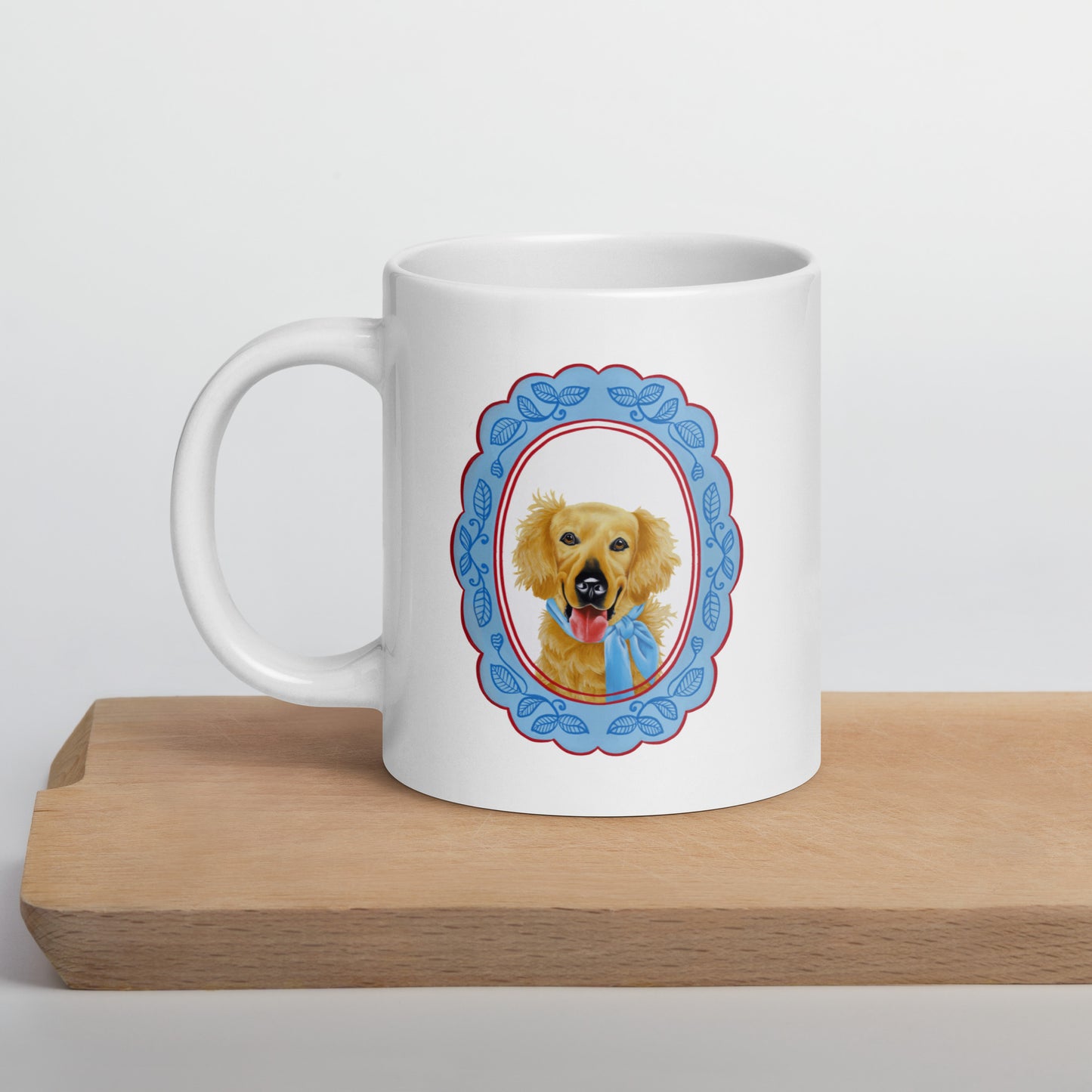 White mug with a dog illustration in a decorative frame on a wooden surface.